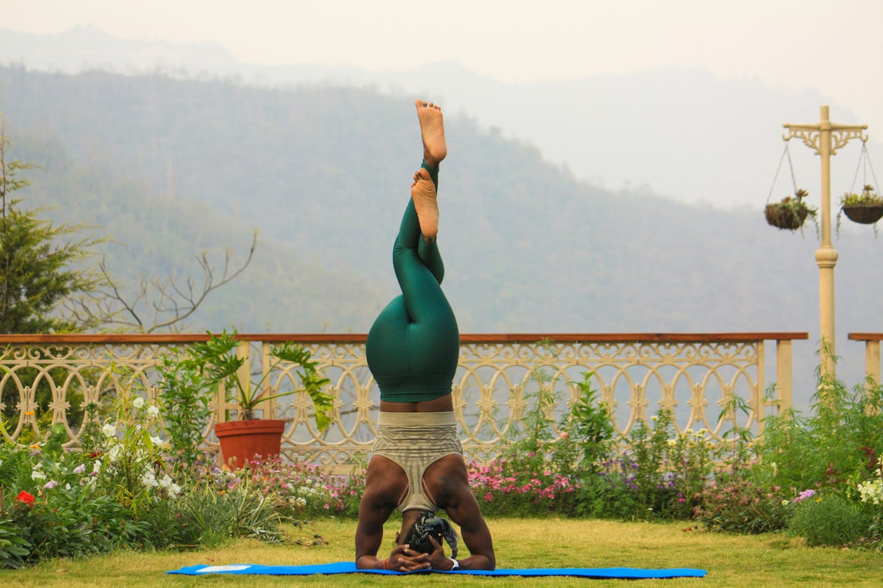 services-01 Person practicing yoga headstand outdoors in scenic Rishikesh, India.
